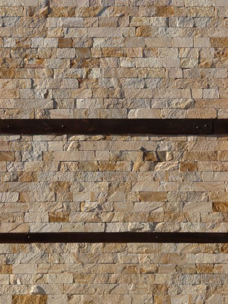 Light stone set linearly with dark wood dividing wall at regular intervals.